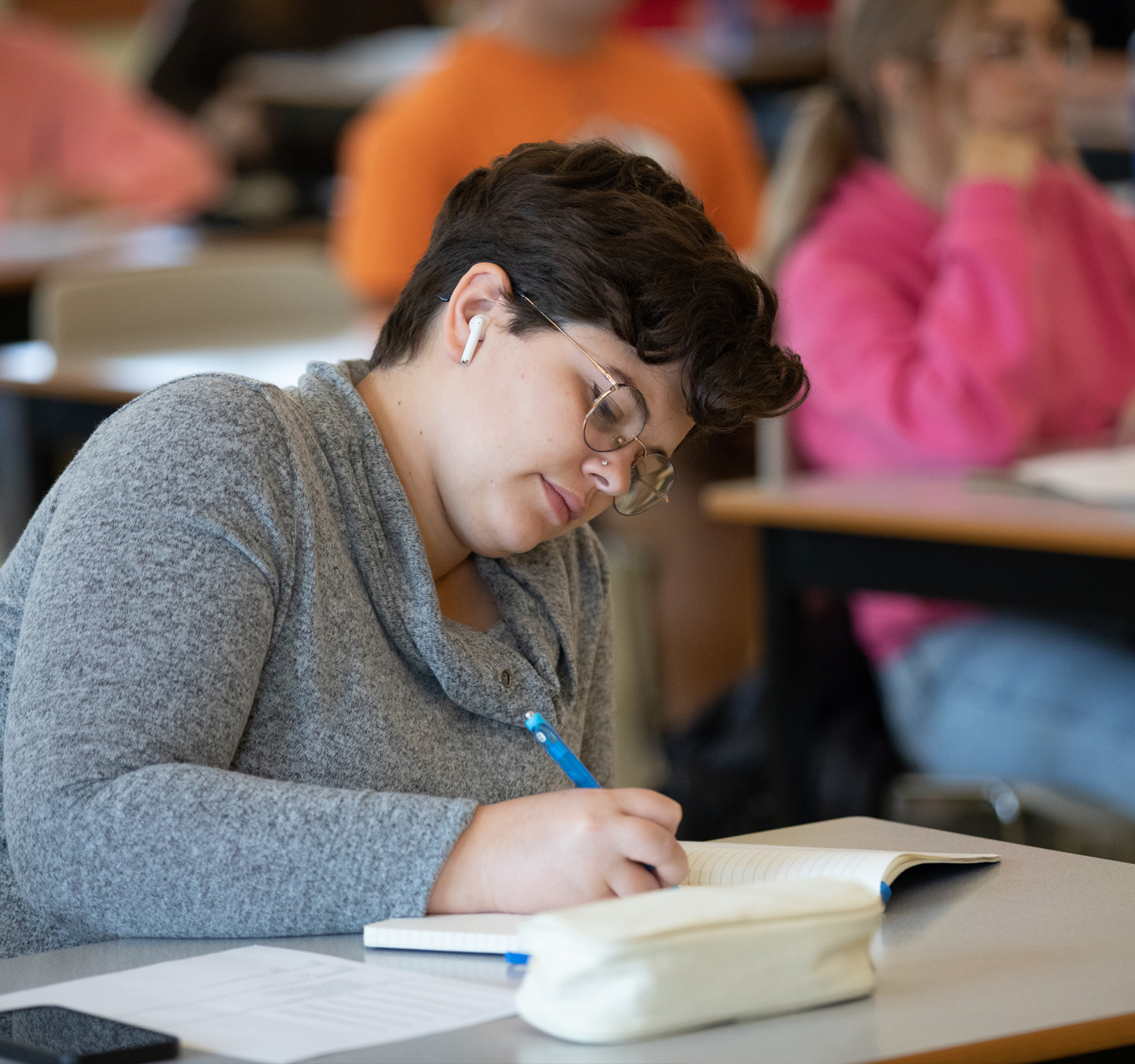 A female student taking notes in class