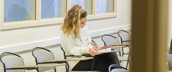 A student studying in an empty classroom