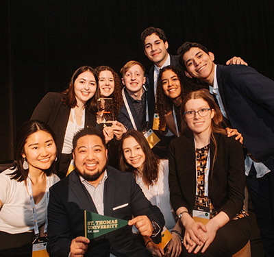 Group of students smiling with glass trophy and STU Pennant at Enactus regional exposition in Halifax