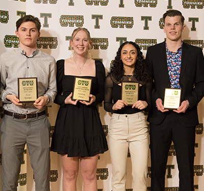 Four students holding awards