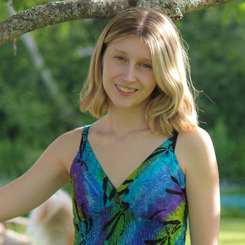 A student standing in front of trees