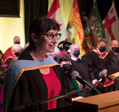 Summer Convocation Valedictorian standing at the podium