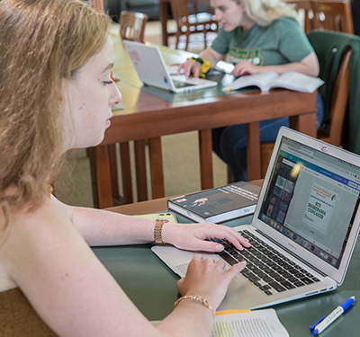 A student designing a graphic on a laptop