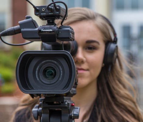 Photo of Journalism student with camera