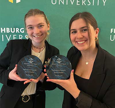 STUdents Jillian Lawrence, left, and Julia Evans, right, hold up their trophies for placing in the top 4 at the AMCA Eastern Regional tournament - November 2022