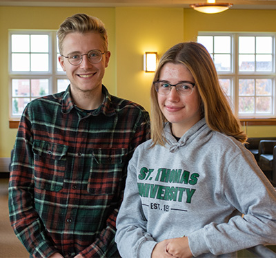 Two students, Pablo Costa (left) and Emily Bessey (right) stand in the Dr. Daniel O'Brien Study Hall