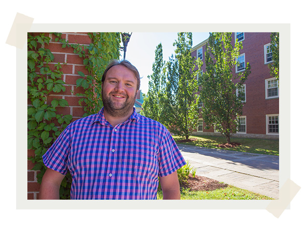 Dr. Jamie Gillies stands in front of a brick building