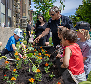 students gardening with teachers