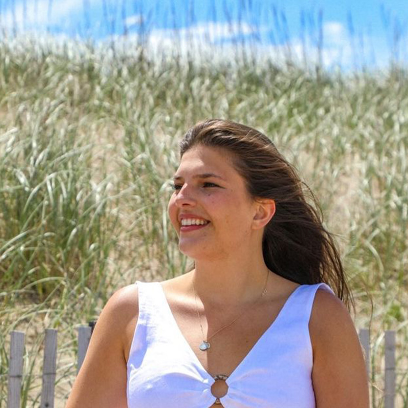 A student standing in front of sand dunes