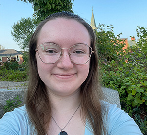 Rebecca smiling in front of campus