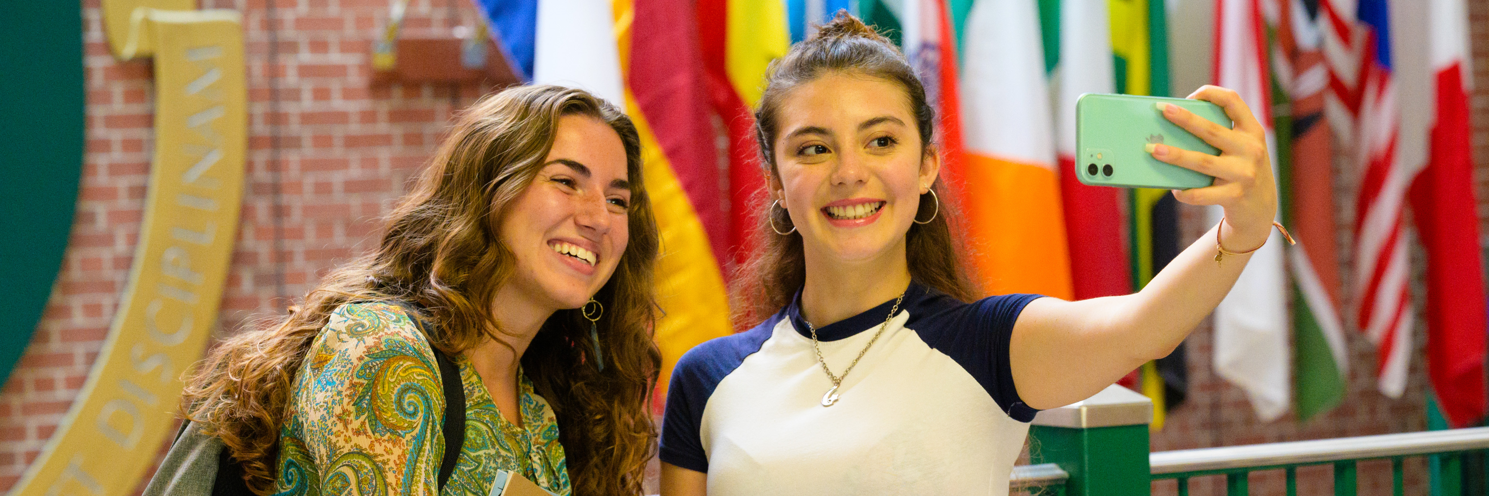 A photo of two female students taking a selfie inside james dunn hall