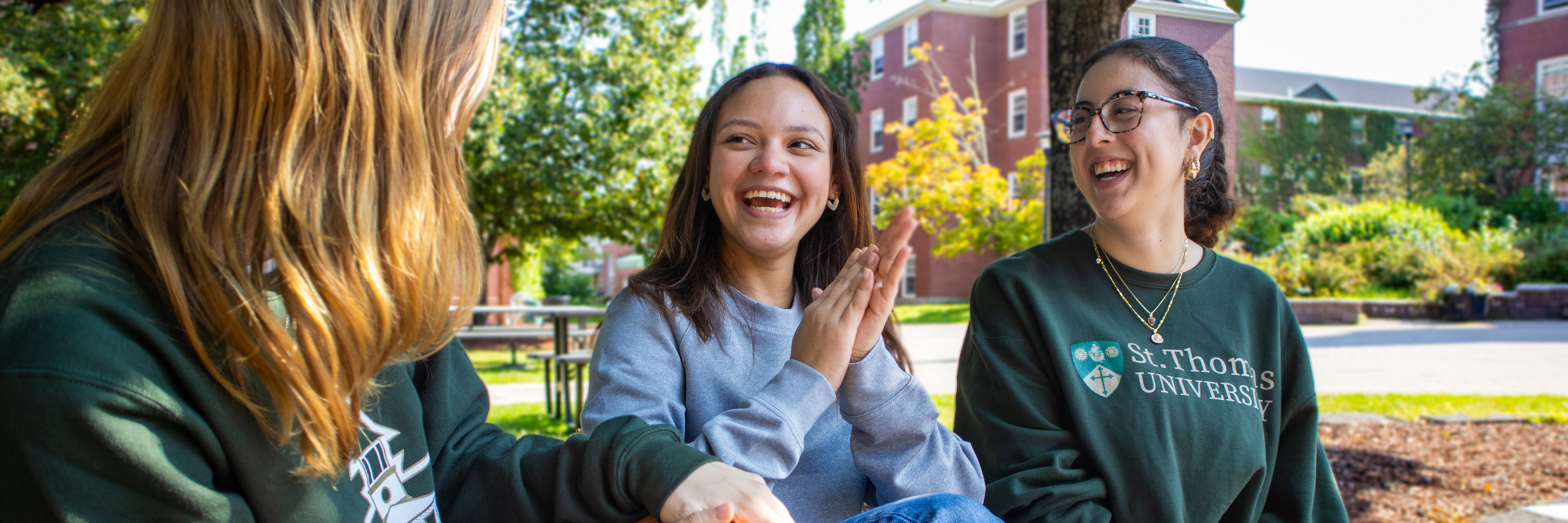 Three students laughing on campus