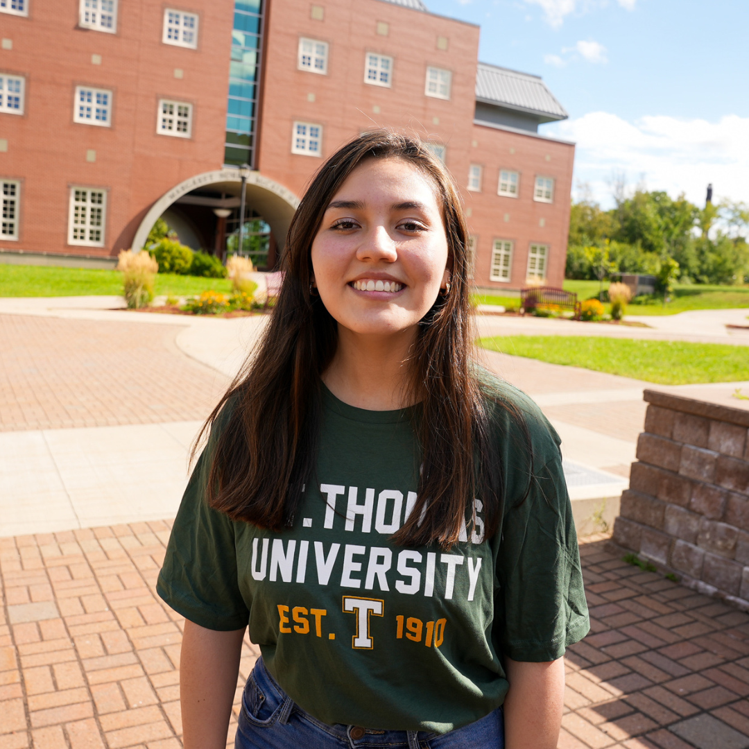 Maria smiling in front of campus