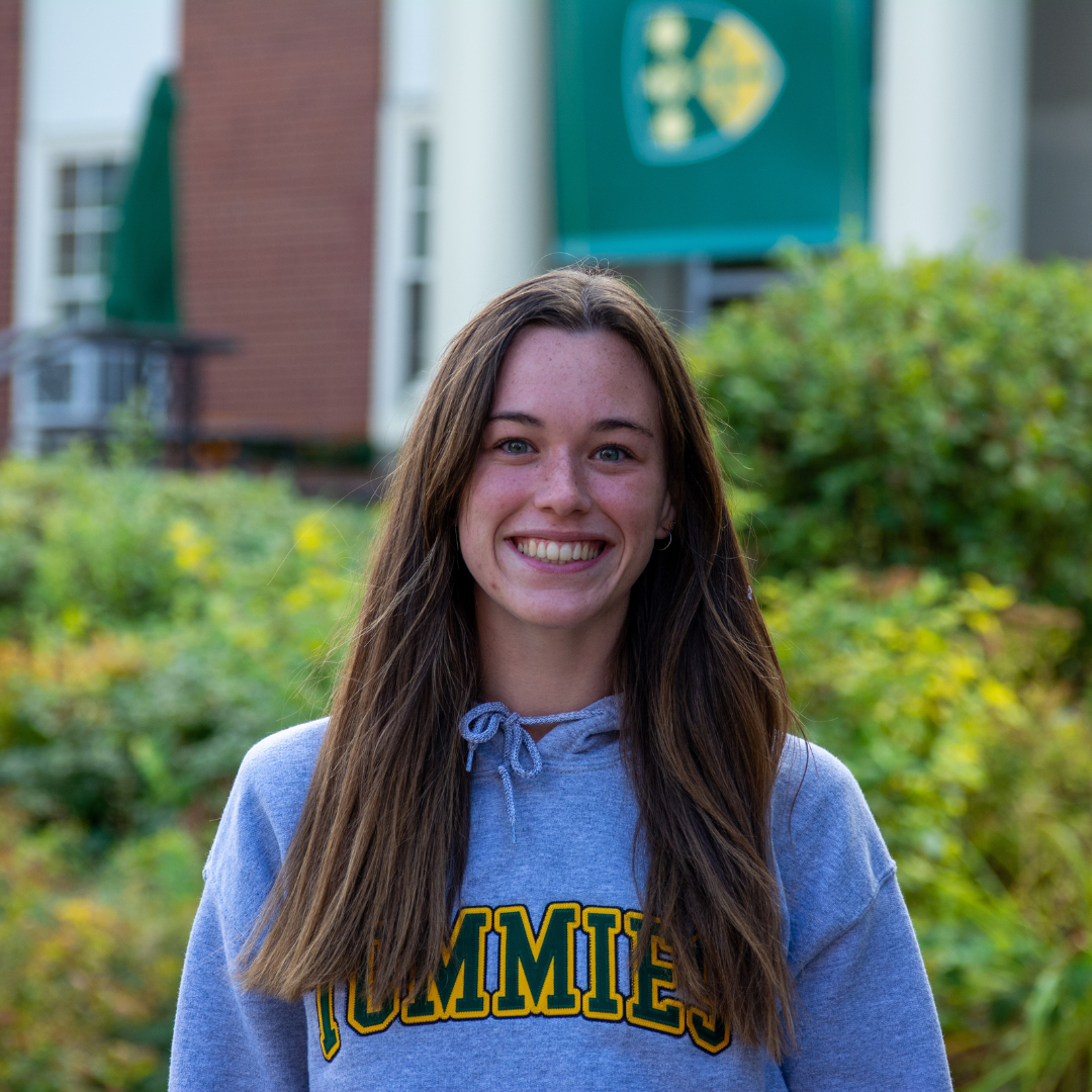 Sarah smiling in front of campus