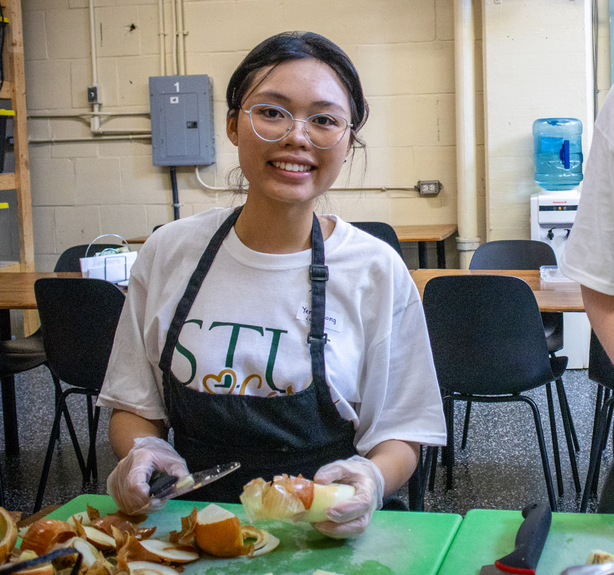 Yen Phuong chopping an onion at the Fredericton Community Kitchens